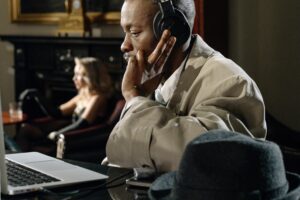 a man wearing a headphone with a laptop is skeptical